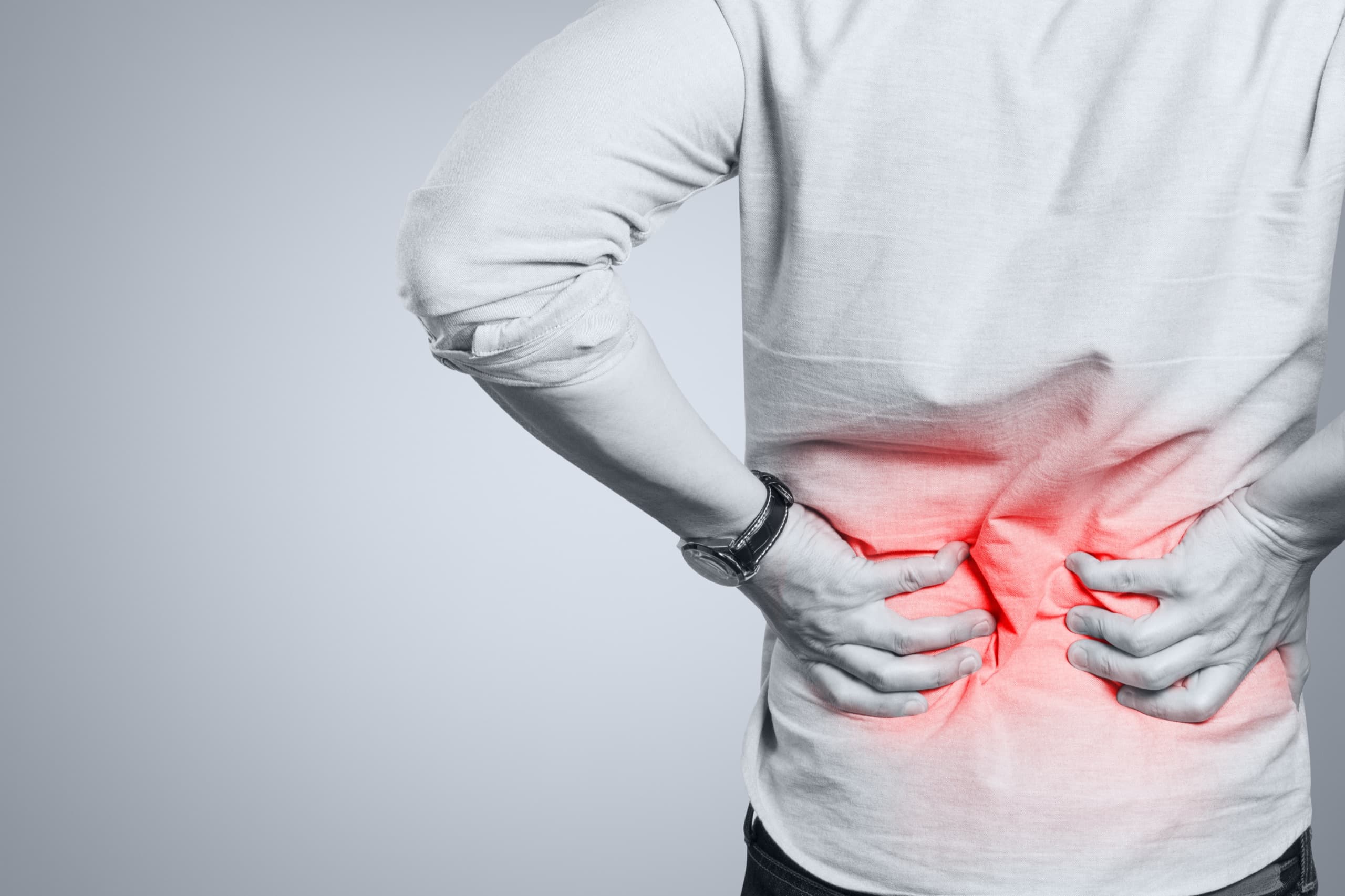 Man pressing his hands into his painful lower back