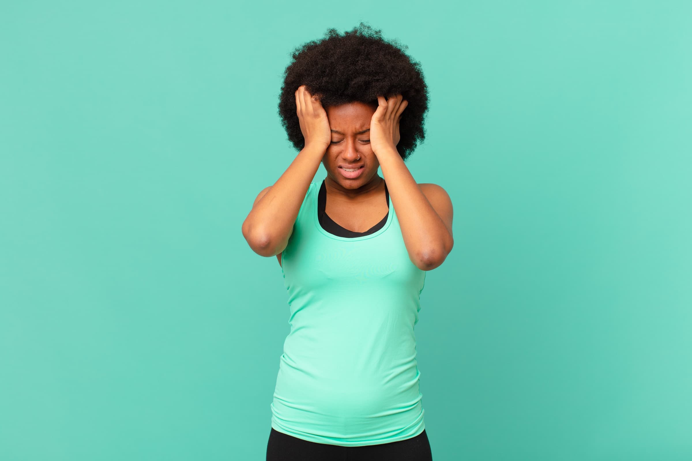 Woman pressing her hands to her head in pain