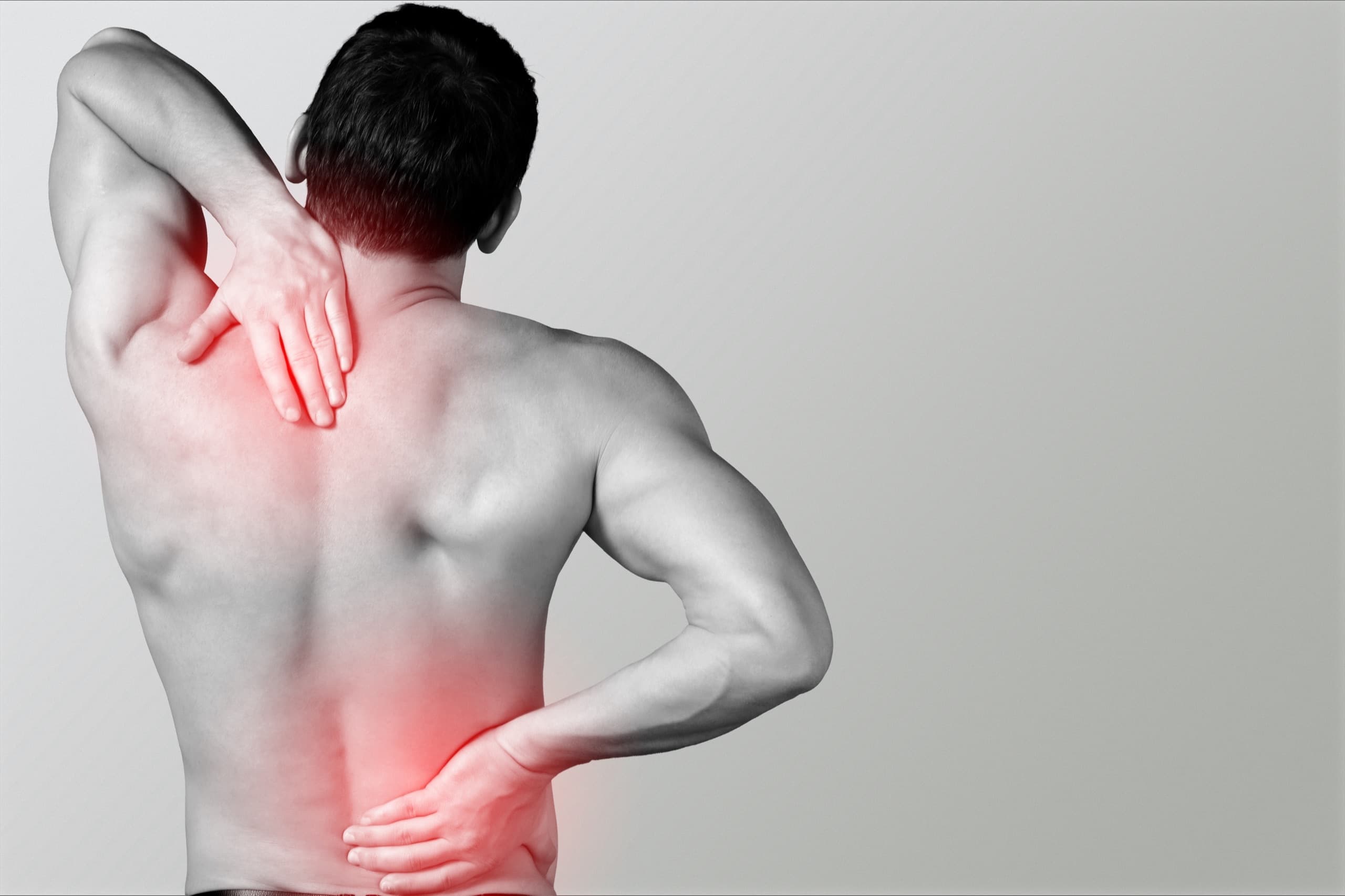 Athlete holding his neck and lower back after a strain