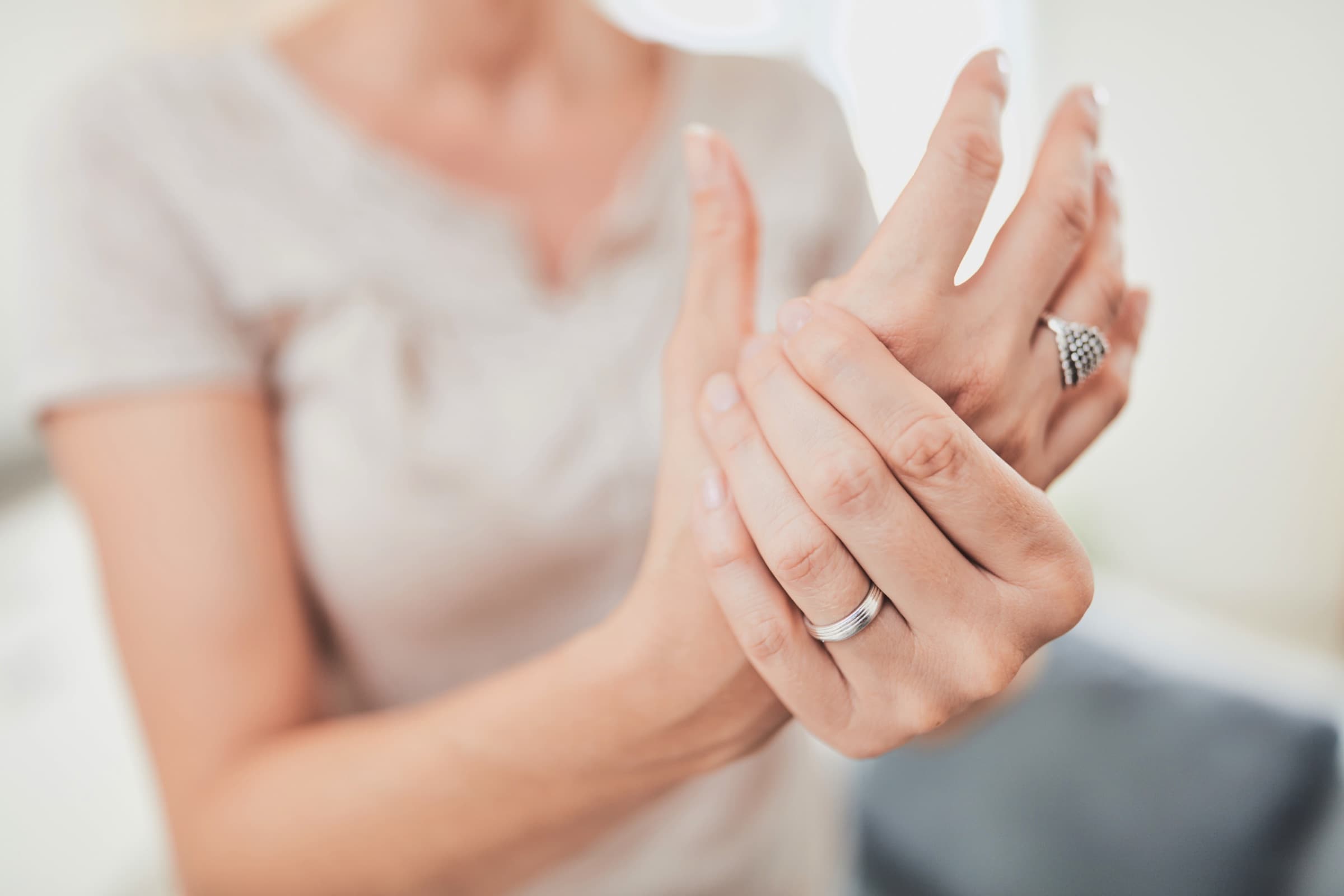 Woman holding her aching hand and finger joints