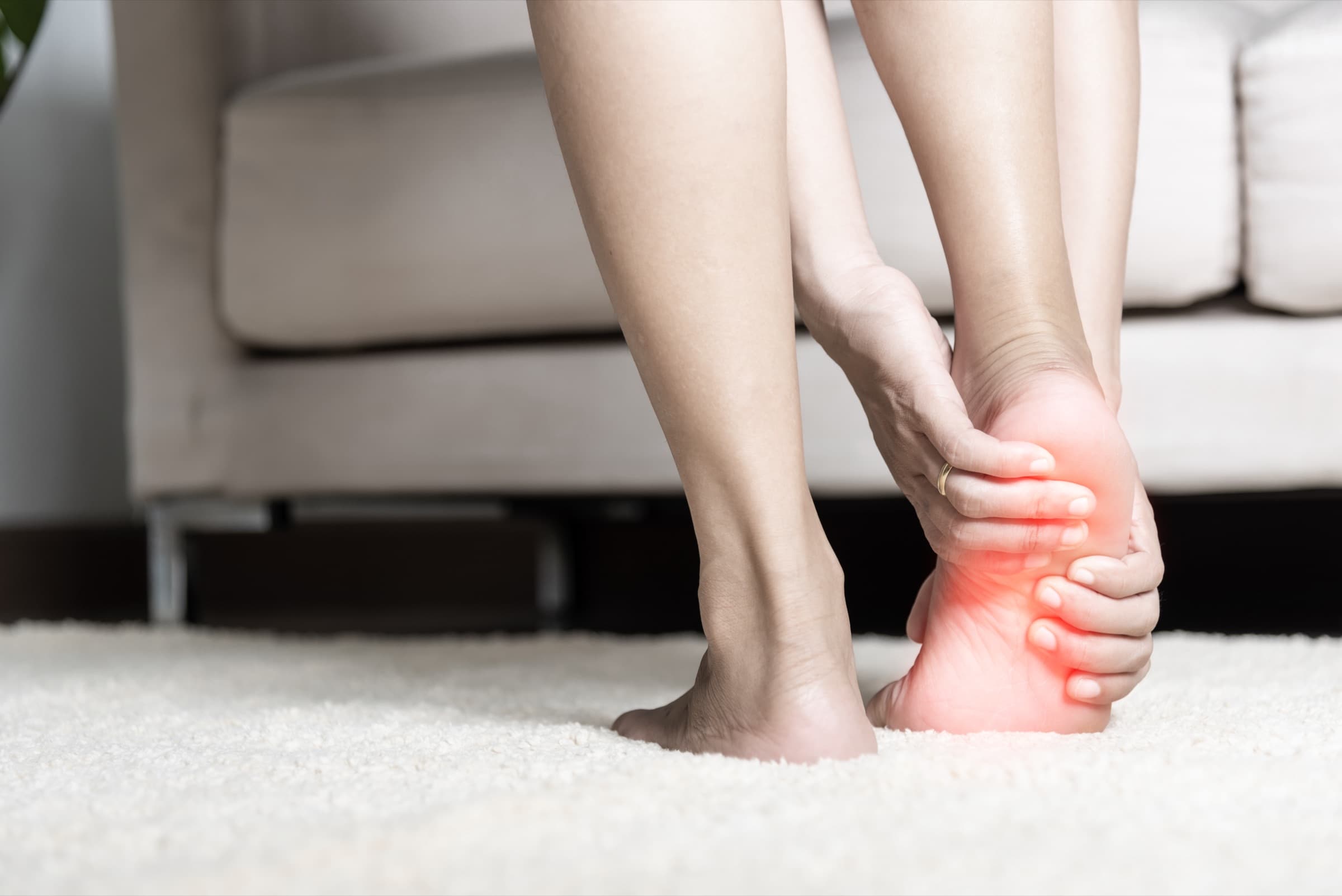 Person holding a foot with burning nerve pain