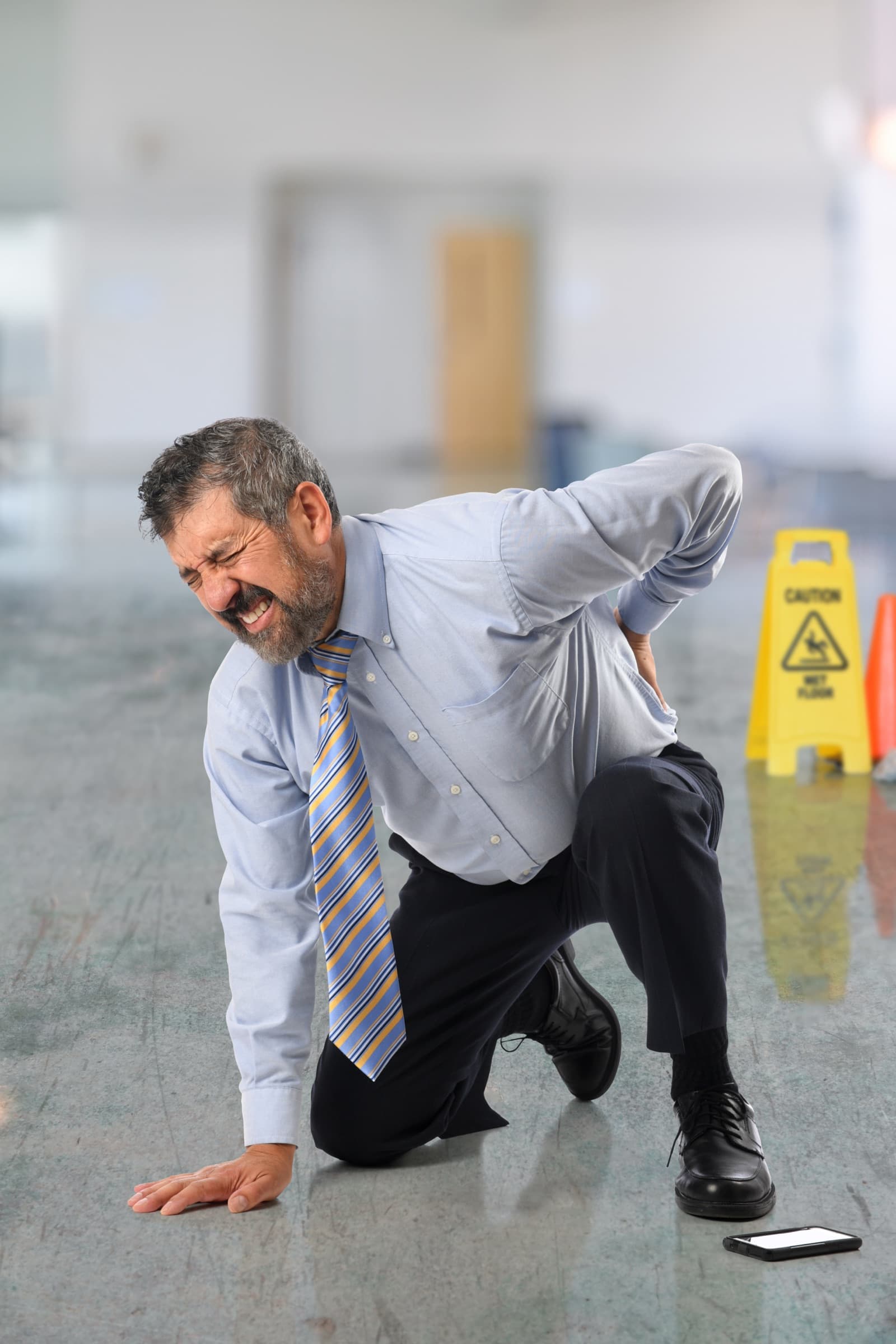 Man with back pain after slipping on a wet floor